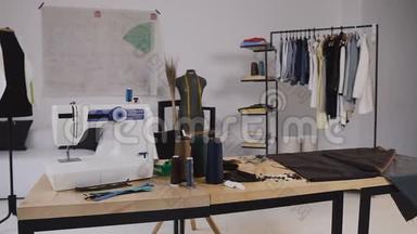 一个时尚的缝纫工作室，里面有缝纫机，线圈线，各种缝纫物品和织物铺设